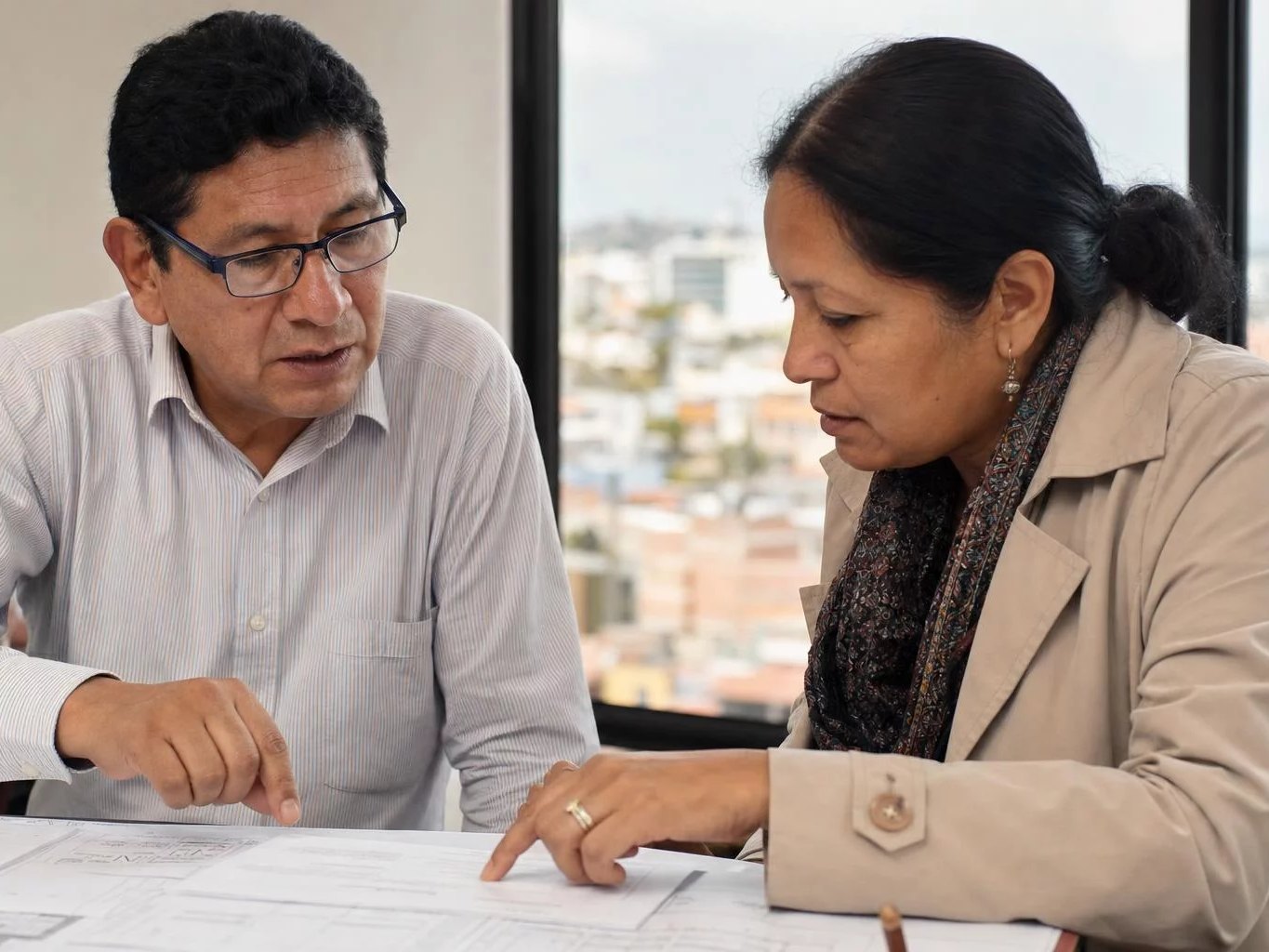 Dos participantes ante una mesa llena de hojas impresas